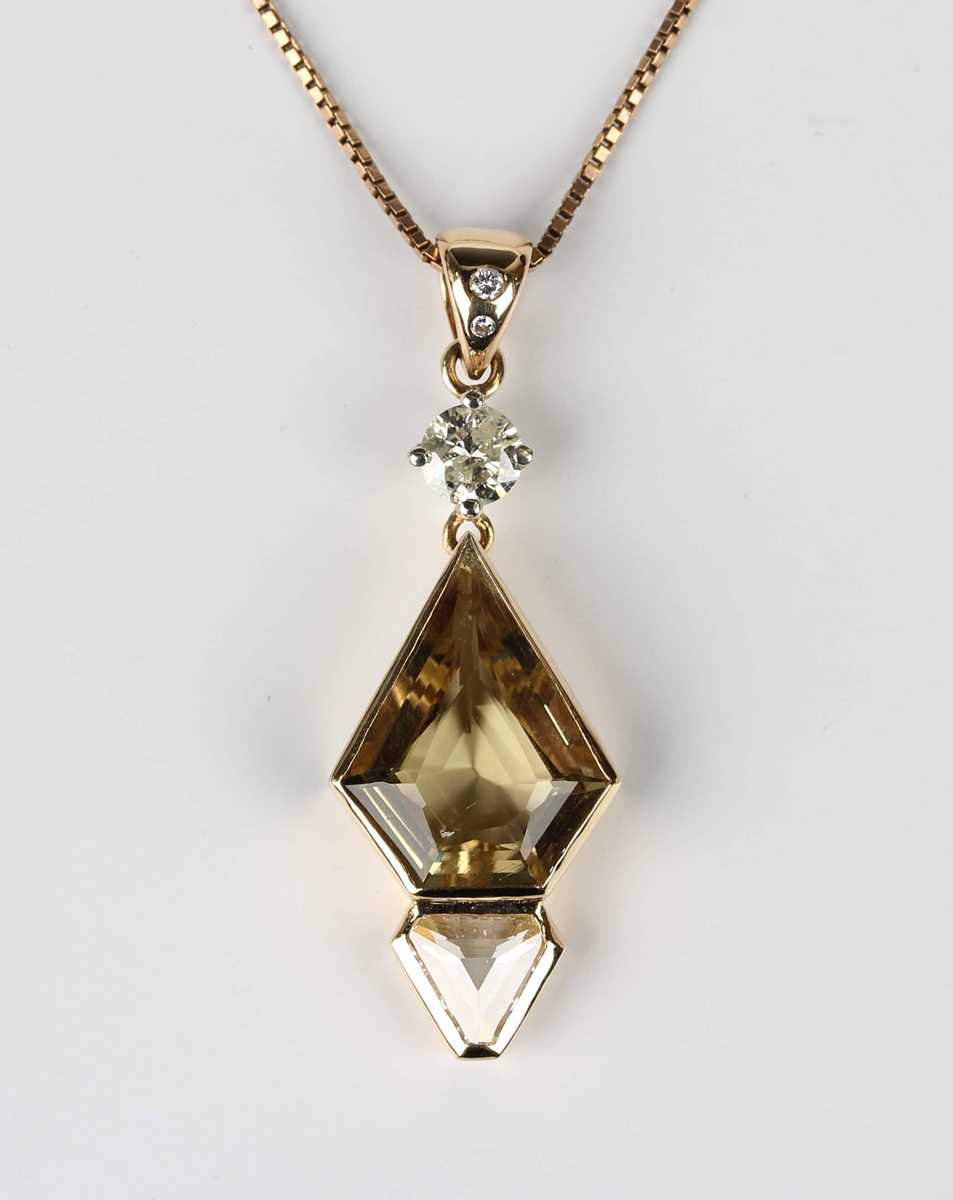 A gold, diamond and citrine pendant, claw set with the principal circular cut diamond above a kite