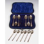 A set of six silver coffee spoons and a pair of matching sugar tongs with engraved decoration,