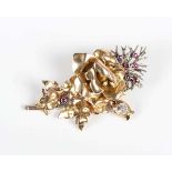 A gold, diamond and ruby brooch, designed as a floral spray, unmarked, weight 12.8g, width 4.9cm.