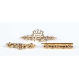 A gold, diamond and seed pearl bar brooch, designed as two diamond set horseshoes alternating with