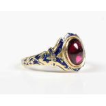 A gold, garnet and blue enamelled ring, collet set with the foil-backed oval cabochon garnet between