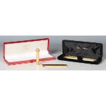 A Must de Cartier gold plated ballpoint pen, cased, together with a Waterman gold plated pen and