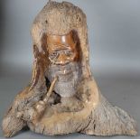 A large late 20th century African carved root sculpture of a man's head with pipe, height 80cm,