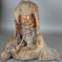 A large late 20th century African carved root sculpture of a man's head with pipe, height 80cm,