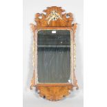 An early 20th century George III style walnut and parcel gilt fretwork wall mirror with a pierced