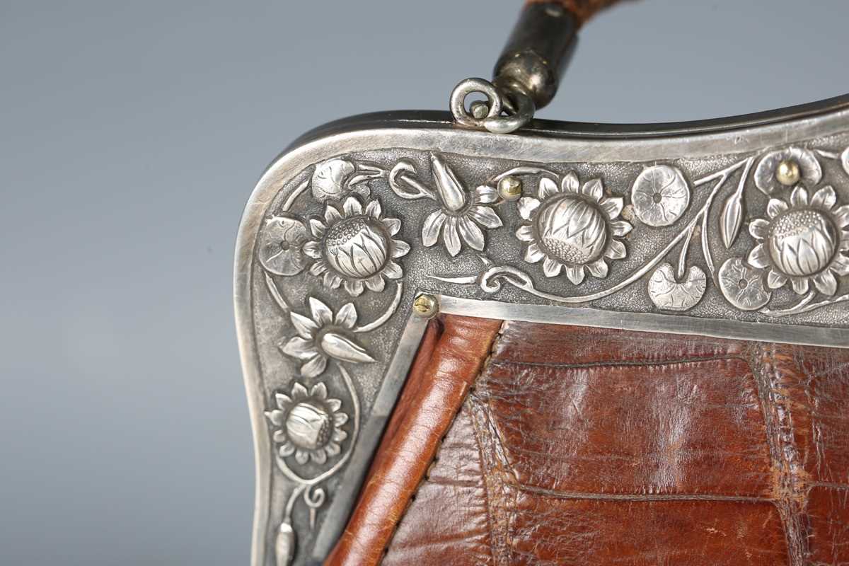 An early 20th century crocodile skin handbag, the white metal clasp decorated with lotus flowers and - Image 4 of 13