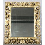 A 20th century Florentine style giltwood rectangular wall mirror with a bevelled glass, 93cm x 77cm.