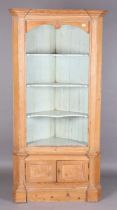 A 19th century pine corner cabinet, the open shelves painted in pale blue above a small two-door