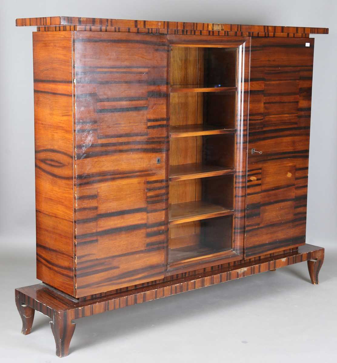 A Continental Art Deco zebrawood side cabinet, fitted with a central bevelled glass compartment