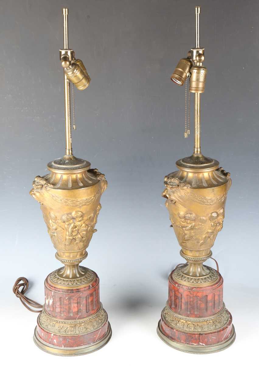 A pair of late 19th century French gilt bronze ornamental urn table lamps, the twin-light fittings