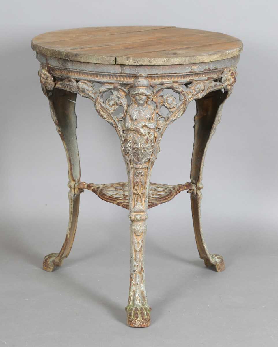 A Victorian cast iron pub table with a later wooden top and 'Britannia' legs, height 75cm,