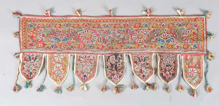 An Indian kutch embroidered door hanging, finely worked in coloured threads, width 98cm. Provenance: