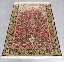 A Qum part silk prayer rug, Central Persia, late 20th century, the red mihrab with an ascending vase
