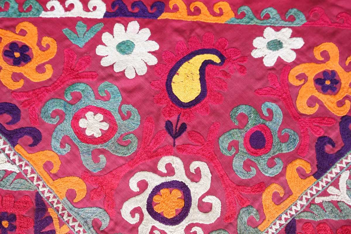 An Uzbekistan silk embroidered suzani, the triangular panel finely worked with scrolling - Image 8 of 12