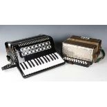 A Hohner accordion and a modern black cased piano accordion.