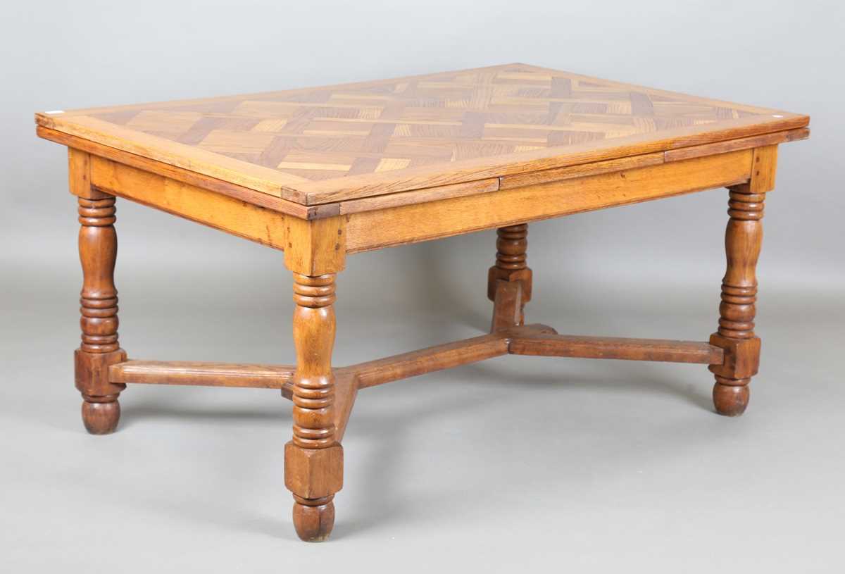 A 20th century French parquetry oak draw-leaf dining table, on turned legs, height 75cm, length
