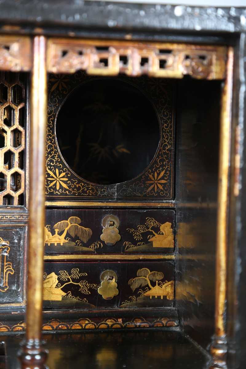 An 18th century Chinese black lacquered collector's cabinet, decorated in gilt with landscape - Image 7 of 28