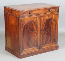 An early Victorian mahogany wash cabinet, fitted with a hinged lid above two arch panelled doors,