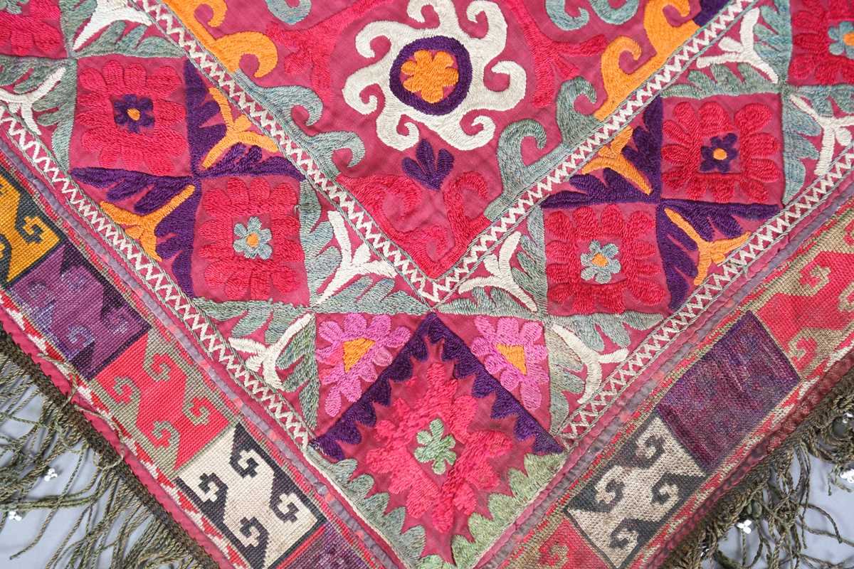 An Uzbekistan silk embroidered suzani, the triangular panel finely worked with scrolling - Image 3 of 12
