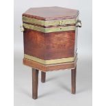 A George III mahogany hexagonal wine cooler with brass bound body and ring handles, raised on a