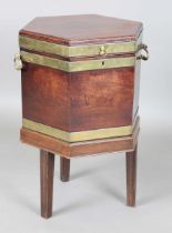 A George III mahogany hexagonal wine cooler with brass bound body and ring handles, raised on a