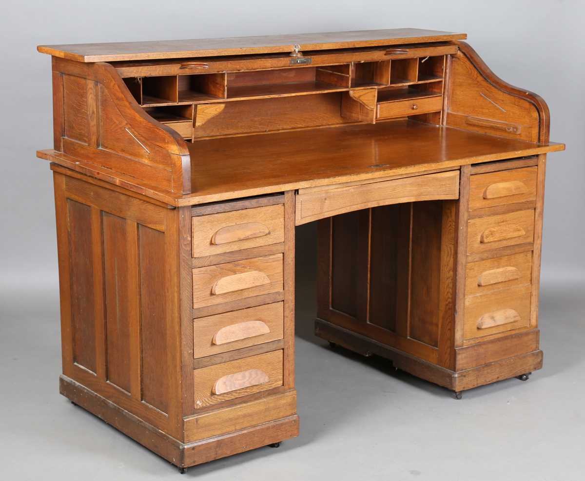 An Art Deco oak roll-top desk, fitted with an arrangement of drawers, height 114cm, width 150cm,