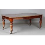 A mid-Victorian mahogany extending dining table, the top with a single extra leaf, raised on