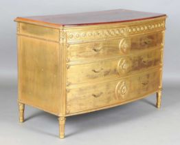 An early 20th century French gilt painted bowfront five-drawer commode, inset with a later top,