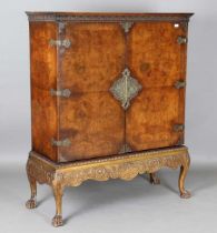 An early 20th century Queen Anne style walnut and gilt metal mounted drinks cabinet, raised on a