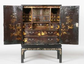 An 18th century Chinese black lacquered collector's cabinet, decorated in gilt with landscape