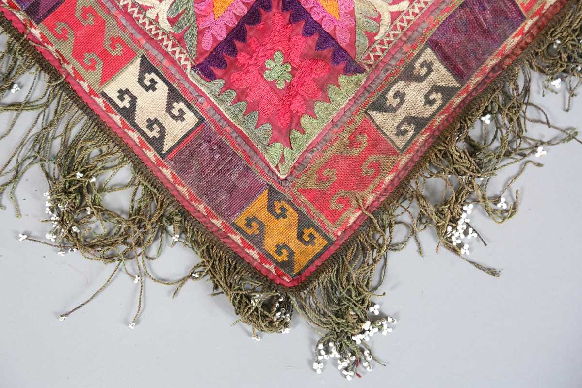 An Uzbekistan silk embroidered suzani, the triangular panel finely worked with scrolling - Image 2 of 12