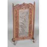 A late Victorian Arts and Crafts oak framed and copper inset firescreen, the panel worked with