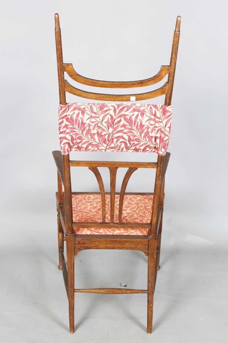 An Edwardian Arts and Crafts oak framed elbow chair, attributed to J.S. Henry, with later fitted - Image 9 of 11