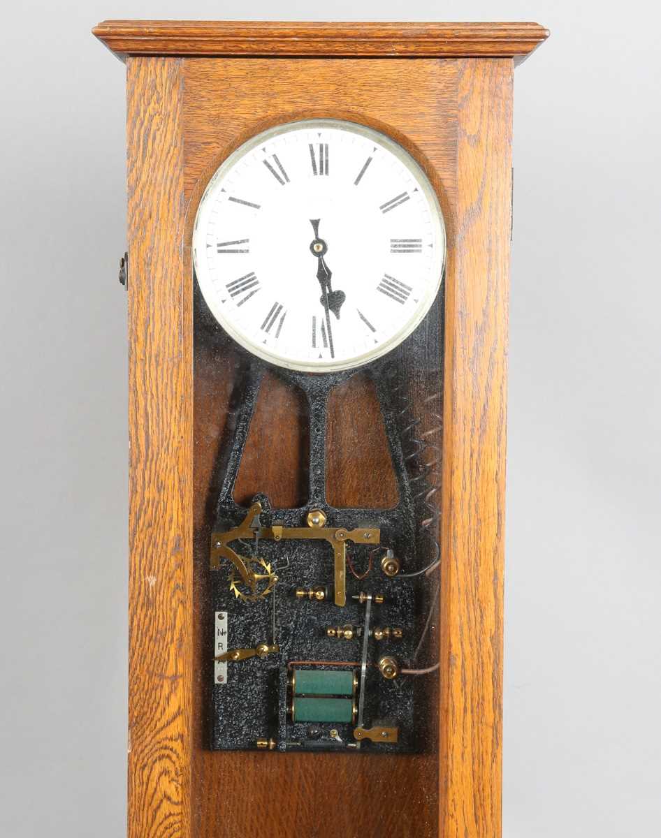 A Synchronome electric master clock, the silvered circular dial with black Roman hour numerals and