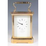 A late 20th century Garrard of London lacquered brass corniche cased carriage clock with eight day