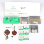 A collection of assorted wristwatch parts, including Rolex and Piaget aluminium small parts cases, a