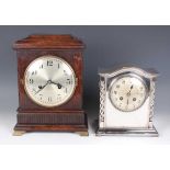 A George V oak mantel clock with eight day movement striking on a gong, the silvered circular dial