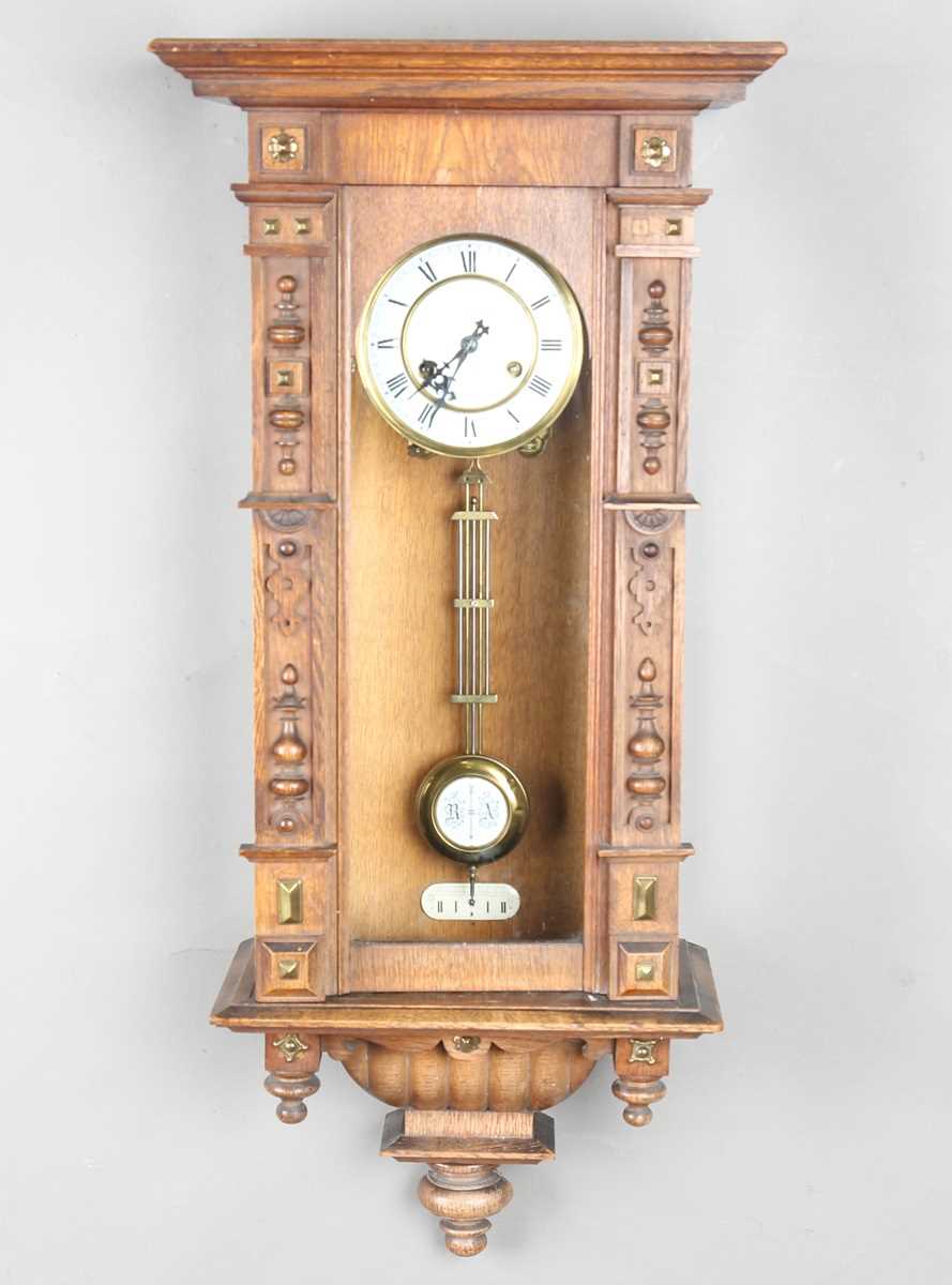 An early 20th century German oak cased Vienna style wall clock by Junghans, with eight day