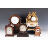 An early 20th century oak mantel clock with eight day movement striking on a gong, the white