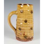 A Doug Fitch studio pottery jug of gently tapered cylindrical form, sprigged with appliqué