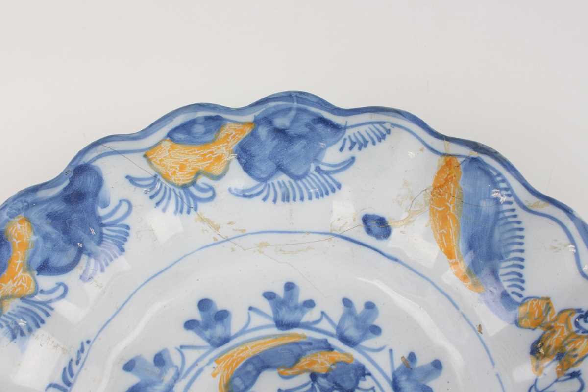 A Dutch Delft lobed buckle dish, circa 1700, painted in blue and yellow with Chinese figures to - Image 5 of 13