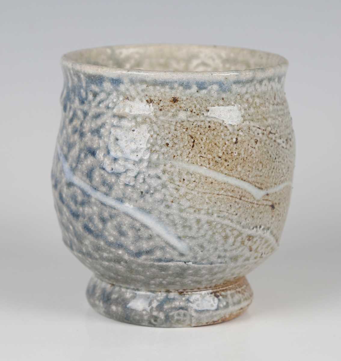 A Ruthanne Tudball stoneware yunomi, decorated in a mottled ash and soda glaze with carved and