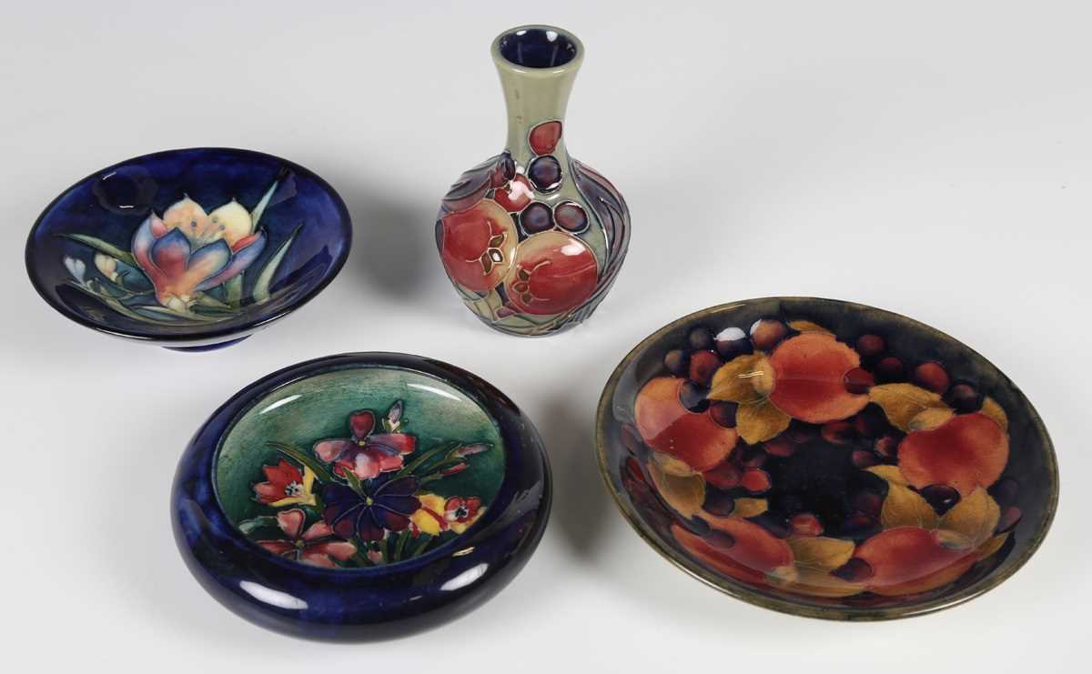 Four pieces of Moorcroft pottery, comprising a Pomegranate pattern saucer, 1920s, diameter 14cm, a