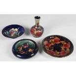 Four pieces of Moorcroft pottery, comprising a Pomegranate pattern saucer, 1920s, diameter 14cm, a