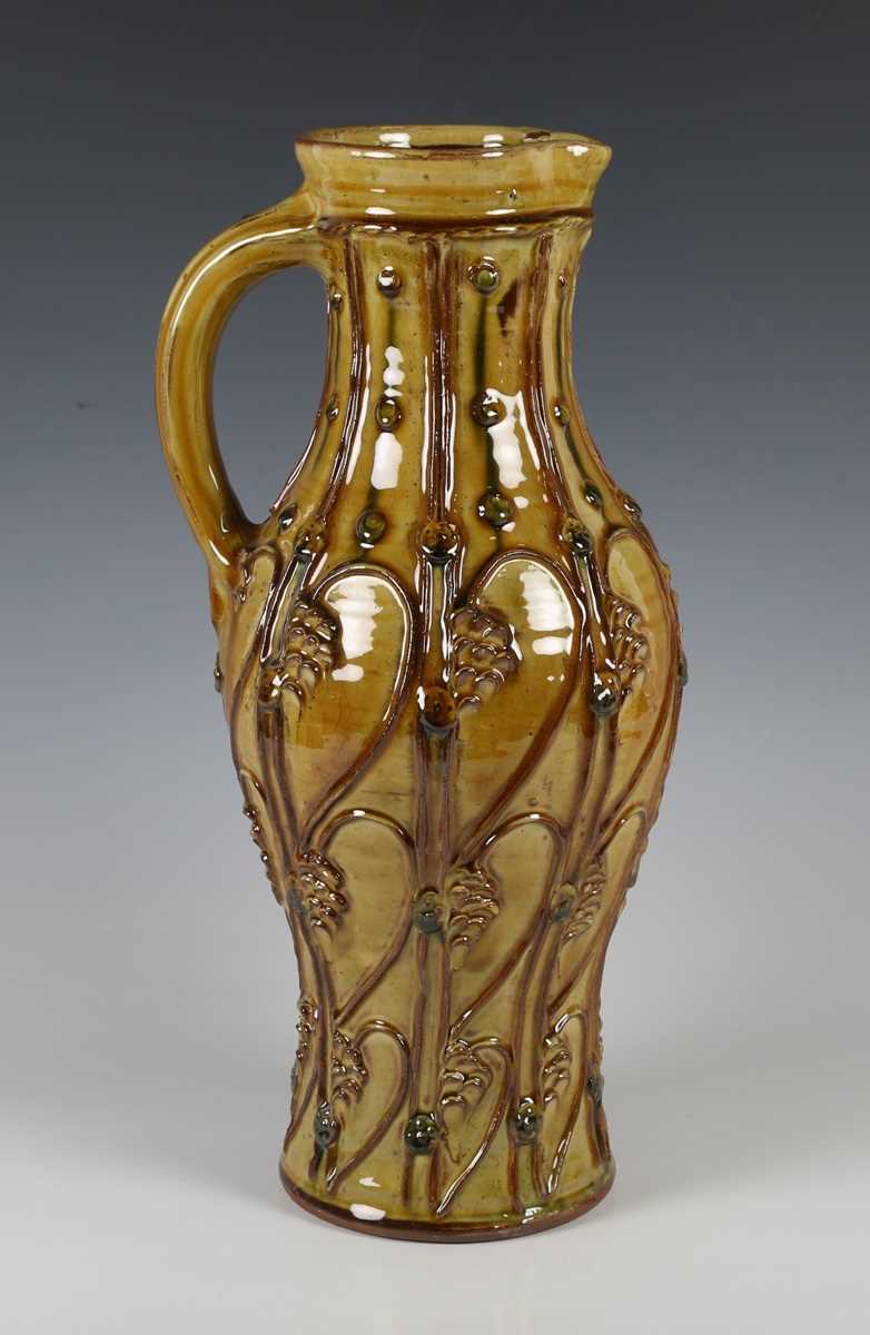 A large Doug Fitch studio pottery jug, the ochre glazed pear shaped body with appliqué medieval