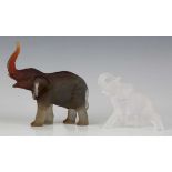 A Daum frosted amber glass model of an elephant with raised trunk, contemporary, designed by Jean-