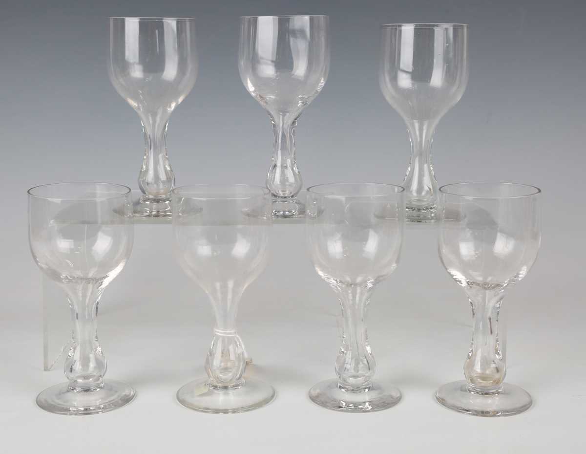 A set of seven hollow stem wine glasses, late 19th/early 20th century, the rounded funnel bowls