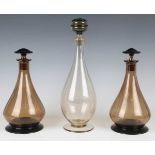 A pair of glass decanters and stoppers, probably Scandinavian, the pear shaped amber glass bodies
