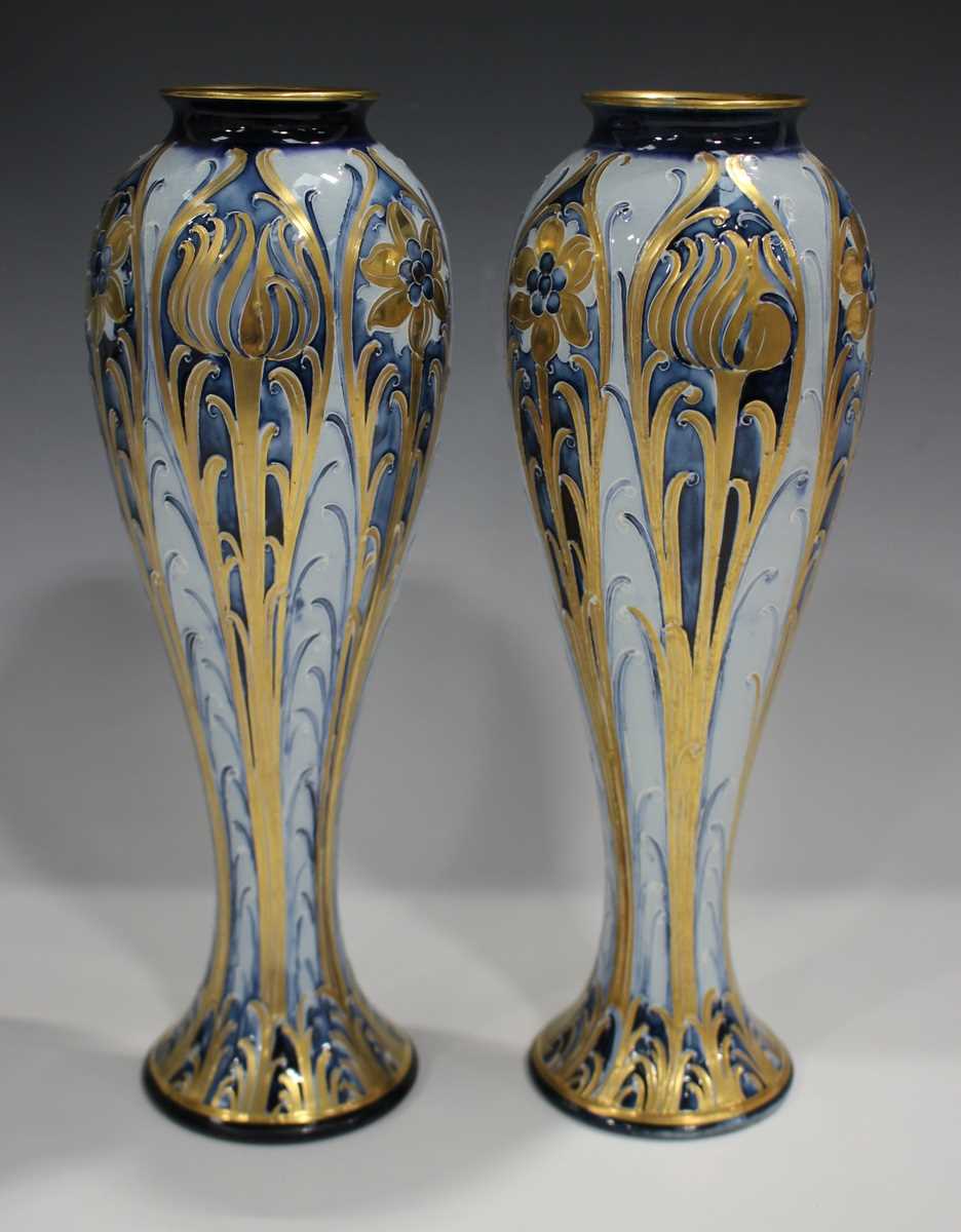 A pair of Macintyre Moorcroft blue and gold Florian design vases, early 20th century, with tall - Image 2 of 6