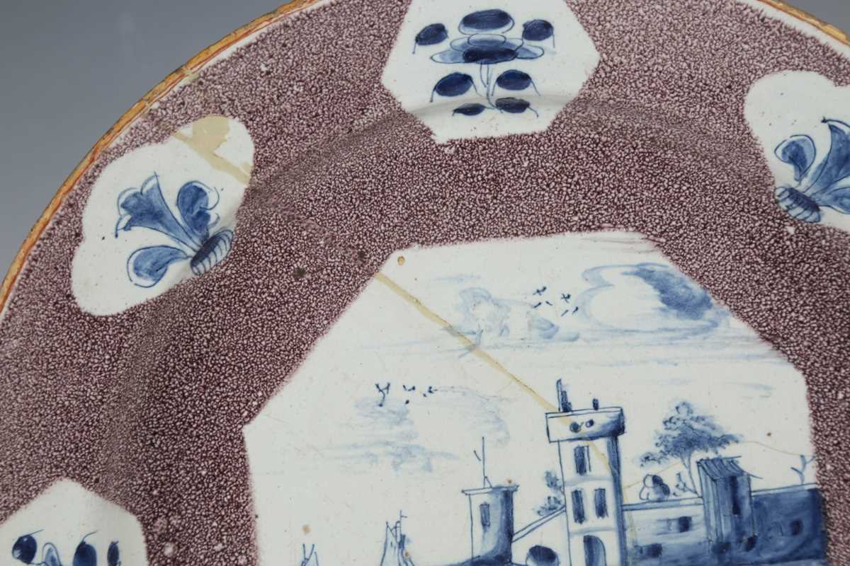 A manganese powdered ground delft dish, Bristol or Wincanton, circa 1740, painted in blue with a - Image 3 of 21